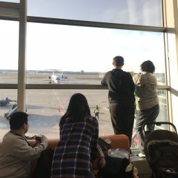 People staring out the window of the airport